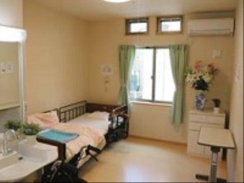 居室の窓際には大輪の美しい花を生けた花瓶が設置されている。洗面台にも観葉植物が置かれており、癒しの空間を演出している。