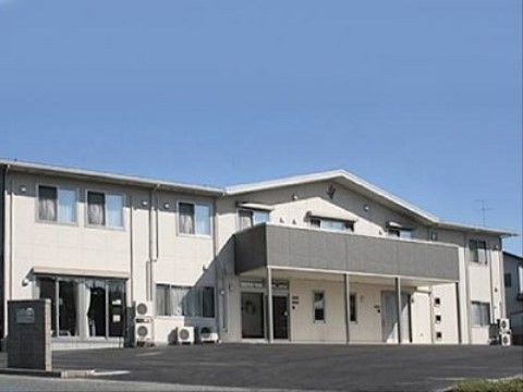 白を基調とした２階建ての外観である。玄関の上部にグレーのフェンスのベランダを設けており、日当たりの良い立地である。