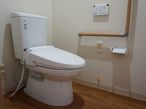 トイレにはＬ字の手すりが設置され、ナースコールが完備されている。使用後の流す等といった操作は壁に設置されたボタンでできる。