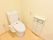 アイボリーの壁を基調としたゆったりとしたトイレ空間。ペーパーホルダーは2つ。下はトイレットペーパーのストックや小物を収納できる収納棚。