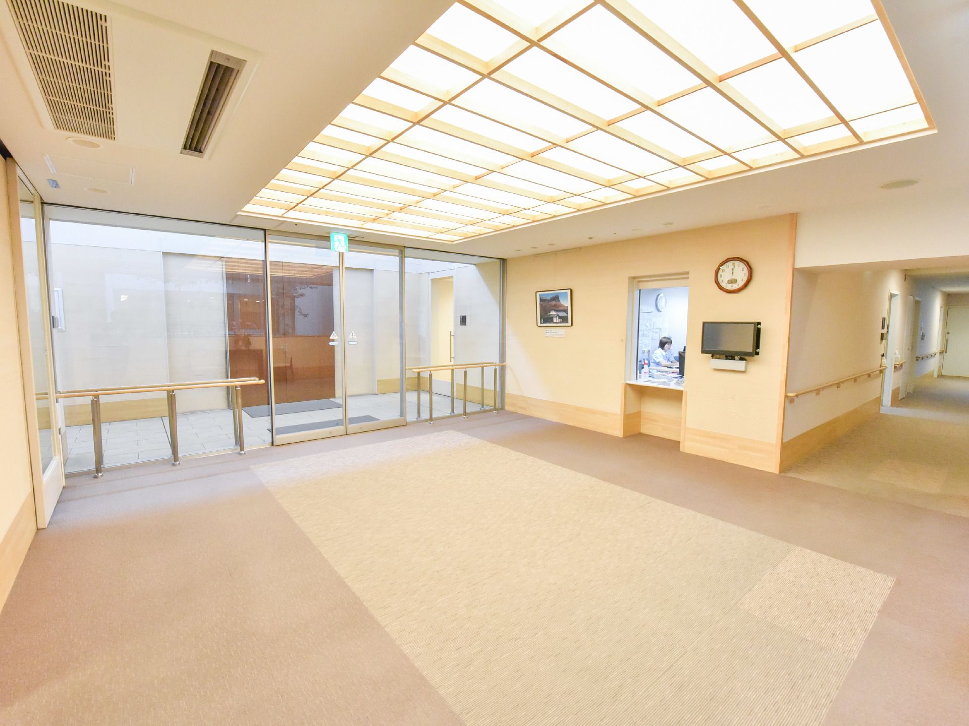 天井いっぱいから自然光が入り込むゆったりとした明るいエントランスホール。出入口は広々としたスペースを確保。自動扉や手すりなど安全面も考慮。