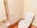 フローリングを採用したトイレ。ゆったりとしたスペースにウォッシュレットトイレを設置。安心の手すり付き。