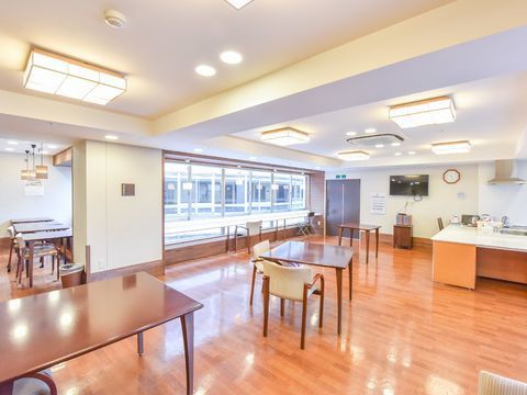 食堂は白壁にフローリングの広いホールになっている。中央にはテーブルと椅子が置かれ、窓際にもテーブルがありカウンター席のようになっている
