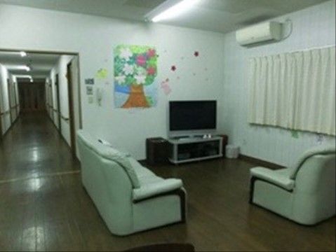 壁の前にテレビが置いてあり、それを囲うようにソファが2脚配置されている。テレビは窓の近くにあり、カーテンが閉めてある。