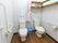 ２つのトイレが並んで置いてあり、間はピンク色のカーテンで仕切ることができる。左のトイレの上には、注意書きの書かれた紙が貼られている。