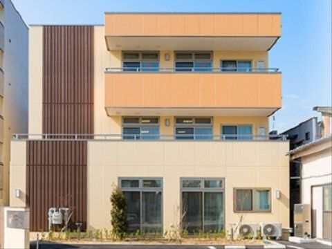 クリーム色とオレンジの2色が使われた、明るく元気な印象の施設外観