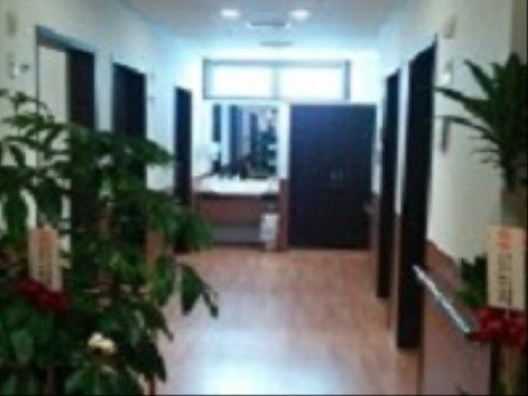 濃い色のフローリングと居室の扉が落ち着いた雰囲気の廊下