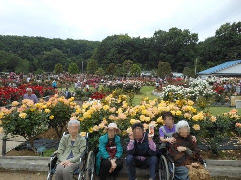 花が咲き乱れる外出先の庭園内で、並んでポーズを取る入居者様
