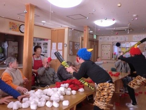 鬼に扮したスタッフにお手玉を投げるゲームに興じる入居者様