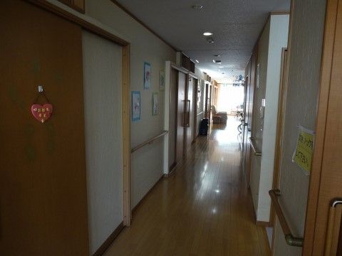 床面はライトベージュ色のフローリングで段差がない。居室のドアは引き戸になっている。両壁面に手すりが付いている。