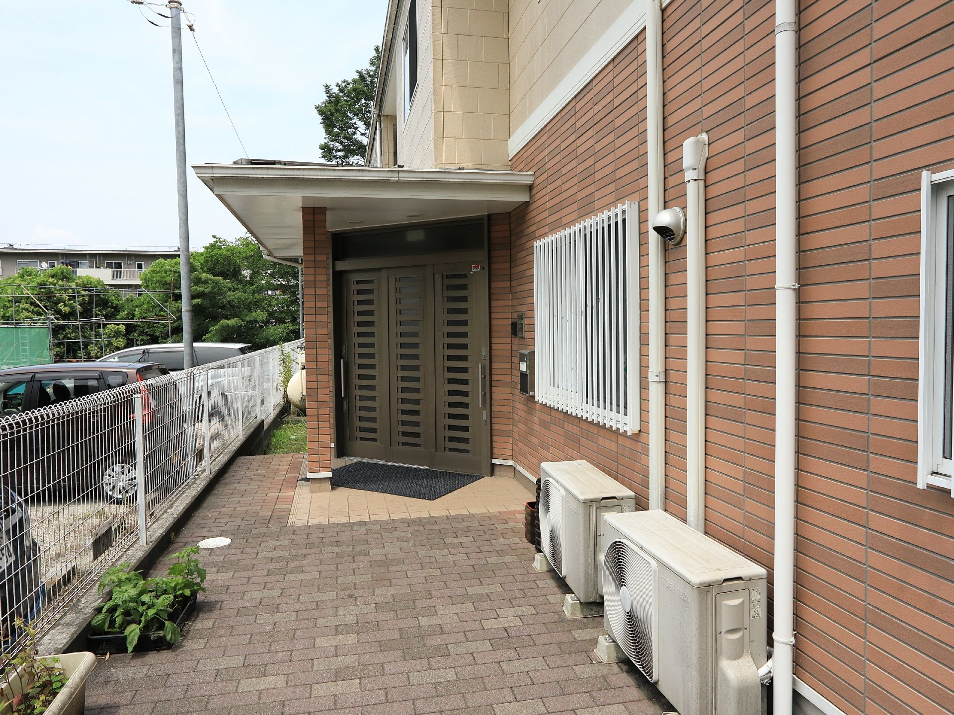 建物は裏口もある。扉前には郵便受けを設置している。それぞれの１階窓は防犯用の格子があるので安心である。
