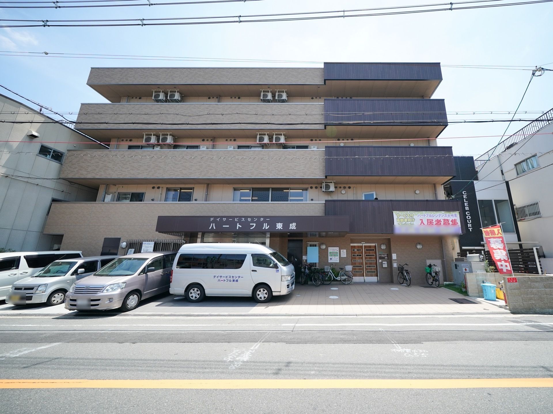 鉄筋コンクリート造の４階建の建物がある。玄関上のひさしの前面に白い文字で施設名が大きく書かれている。