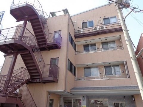 外側に取り付けられた非常階段がある4階建ての施設建物