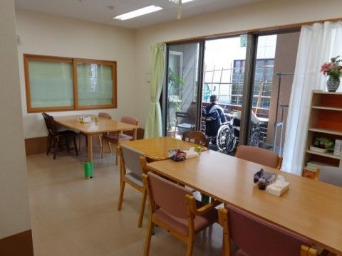 ダイニングセットが間を空けて置いてある。掃き出し窓からは車椅子のままでもベランダへ出られ、外の空気が味わえる。