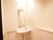 施設内のトイレは広々としており、部屋の隅に洗面台が設置されている。右側には、タオル掛けが取りつけられている。