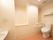 白を基調とした清潔感のある室内には、タンク付きのトイレが完備されている。その正面には、洗面台がある。