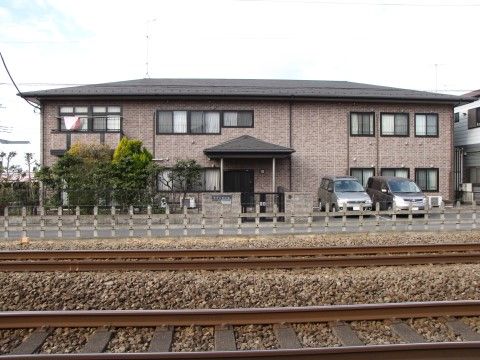 駅近く、線路沿いの住宅地に位置する、2階建て施設の外観