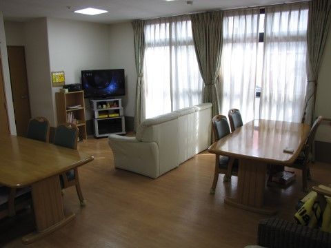 入居者様同士の交流の場として利用されている。床面はフローリングである。長ソファー、木製のテーブルセット、テレビが設置されている。