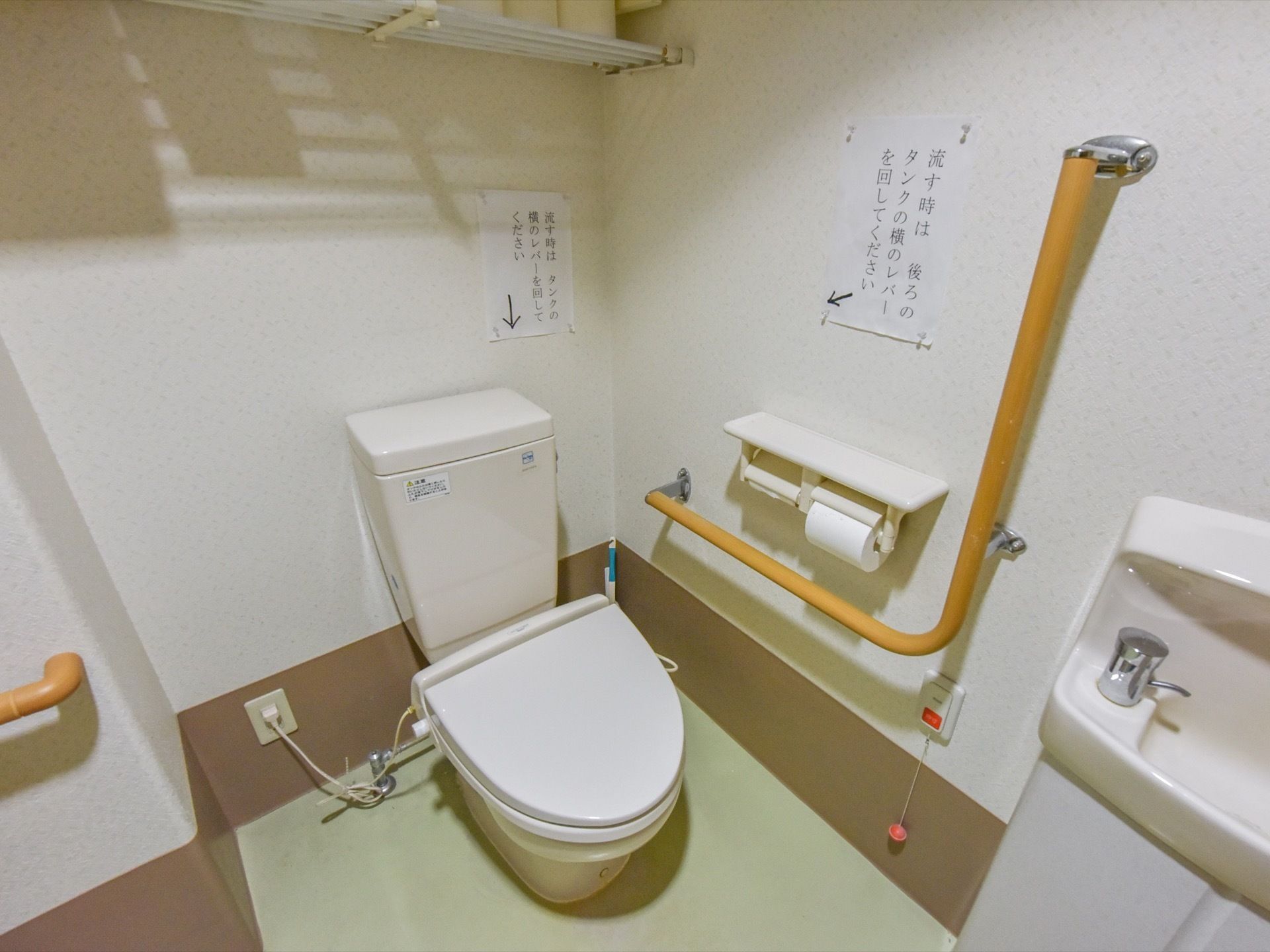 トイレ内の壁には座り立ちや移動をサポートする手すりを複数取り付けている。洋式便器と手洗いの間にはナースコールを設置している。