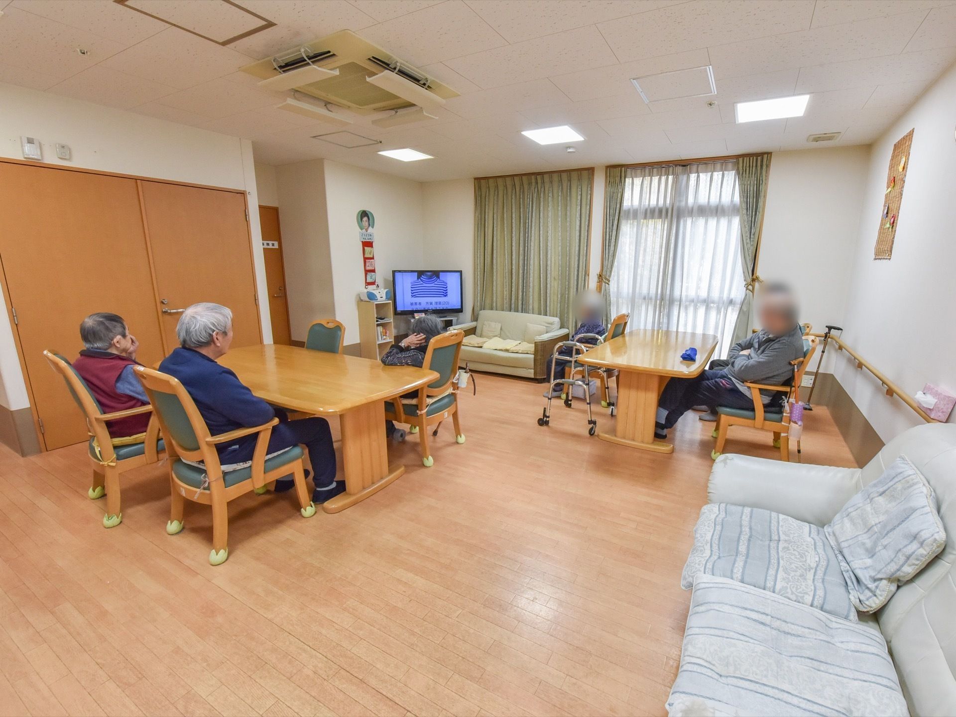 広々としたリビングにテーブルセットとソファーを置いている。コーナー部分には液晶テレビを一台設置している。