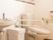 広々としたトイレには手すりが取り付けてある。そばにゴミ箱や洗面台も設置されている。白を基調とした室内は清潔感がある。