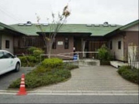グリーンの屋根にブラウンの外壁でシックな平屋建ての施設外観