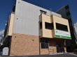 施設は道路沿いにある３階建ての建物である。入口前までは低めの階段があるが、茶色い手すりがついているので安心である。