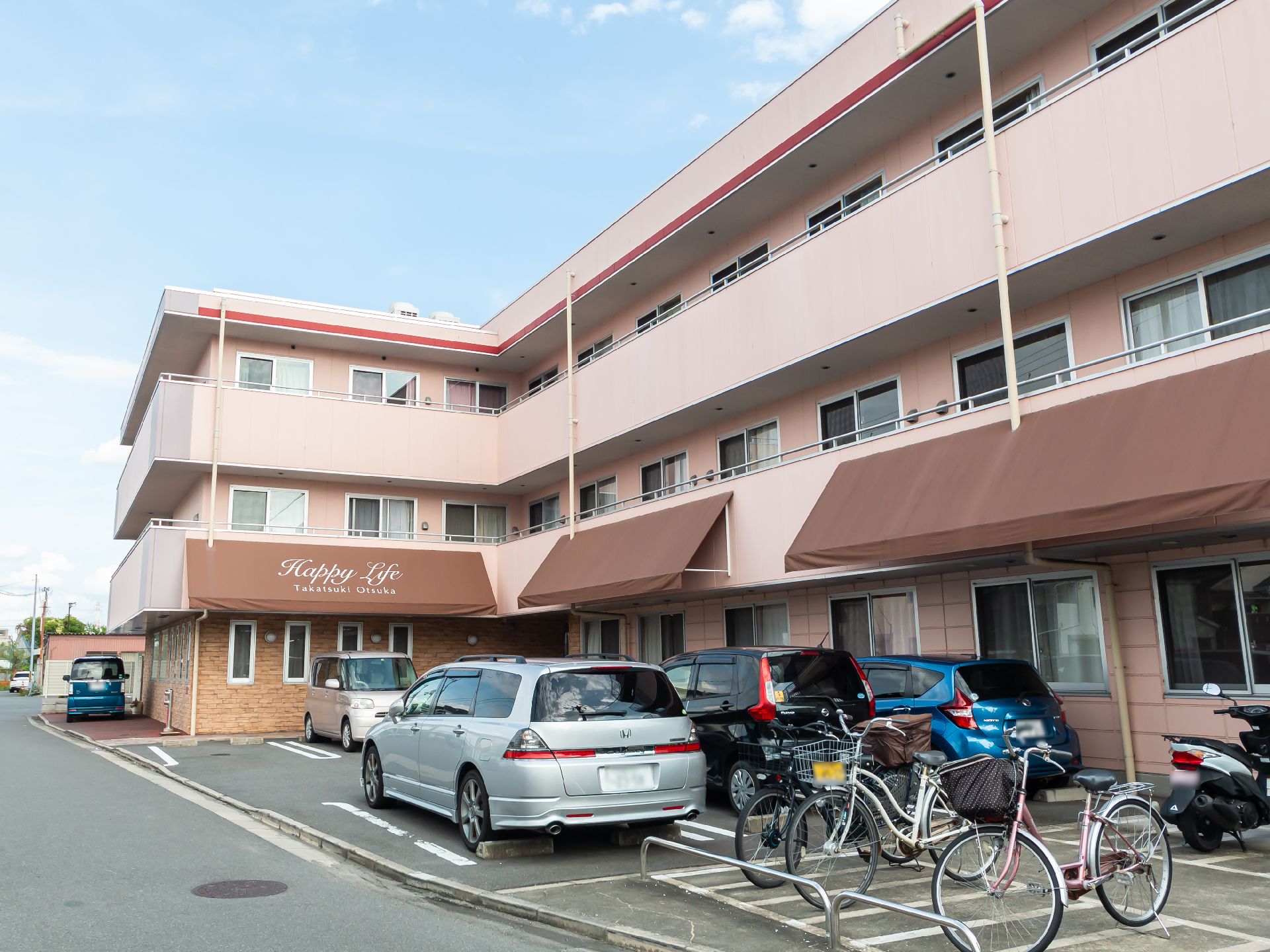ピンクを基調とした３階建ての介護施設の外観