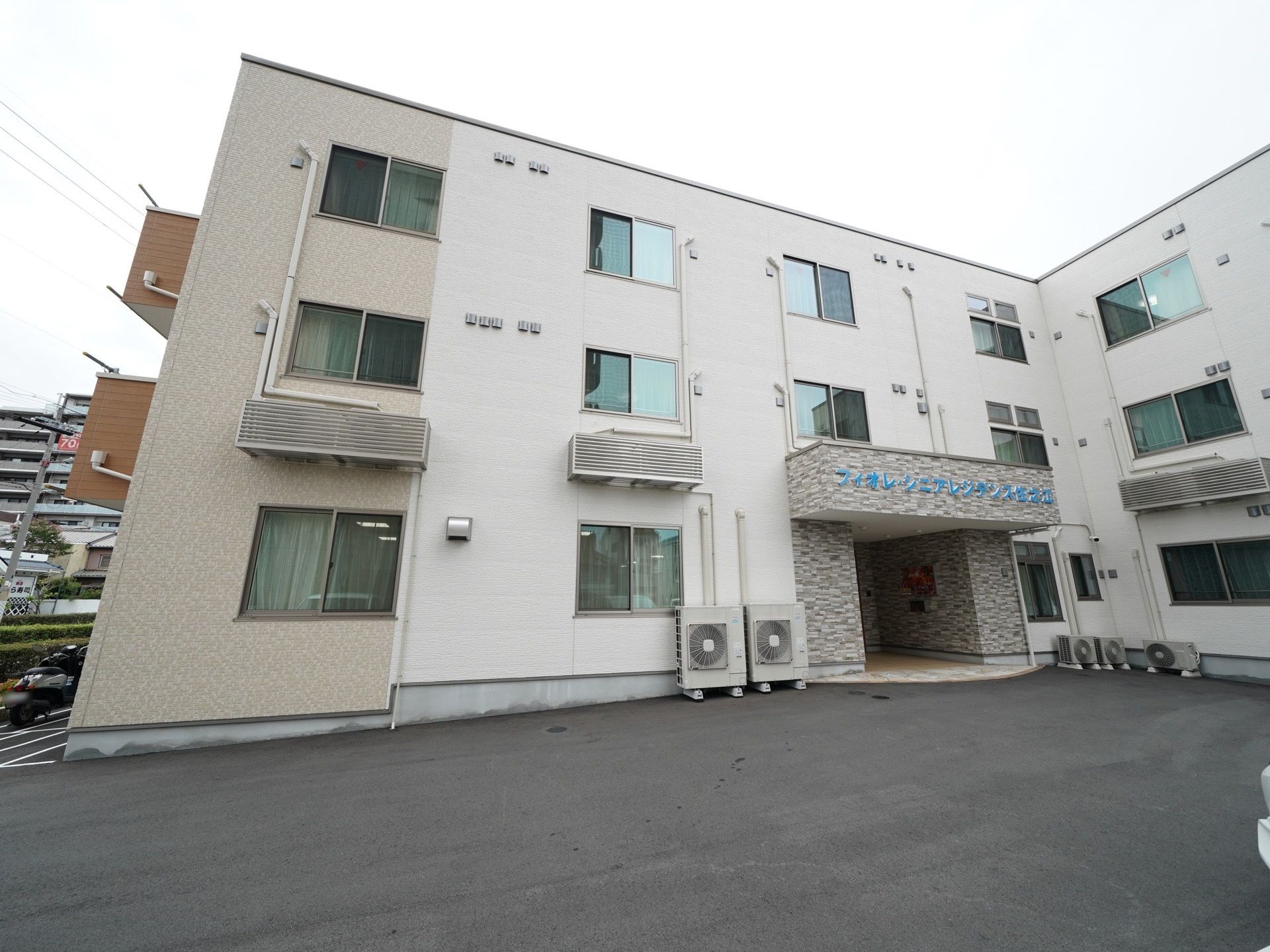 施設は３階建ての建物で、外壁はベージュ色で落ち着いた雰囲気である。広い敷地の中にあり、建物の前はきれいに整備されている。