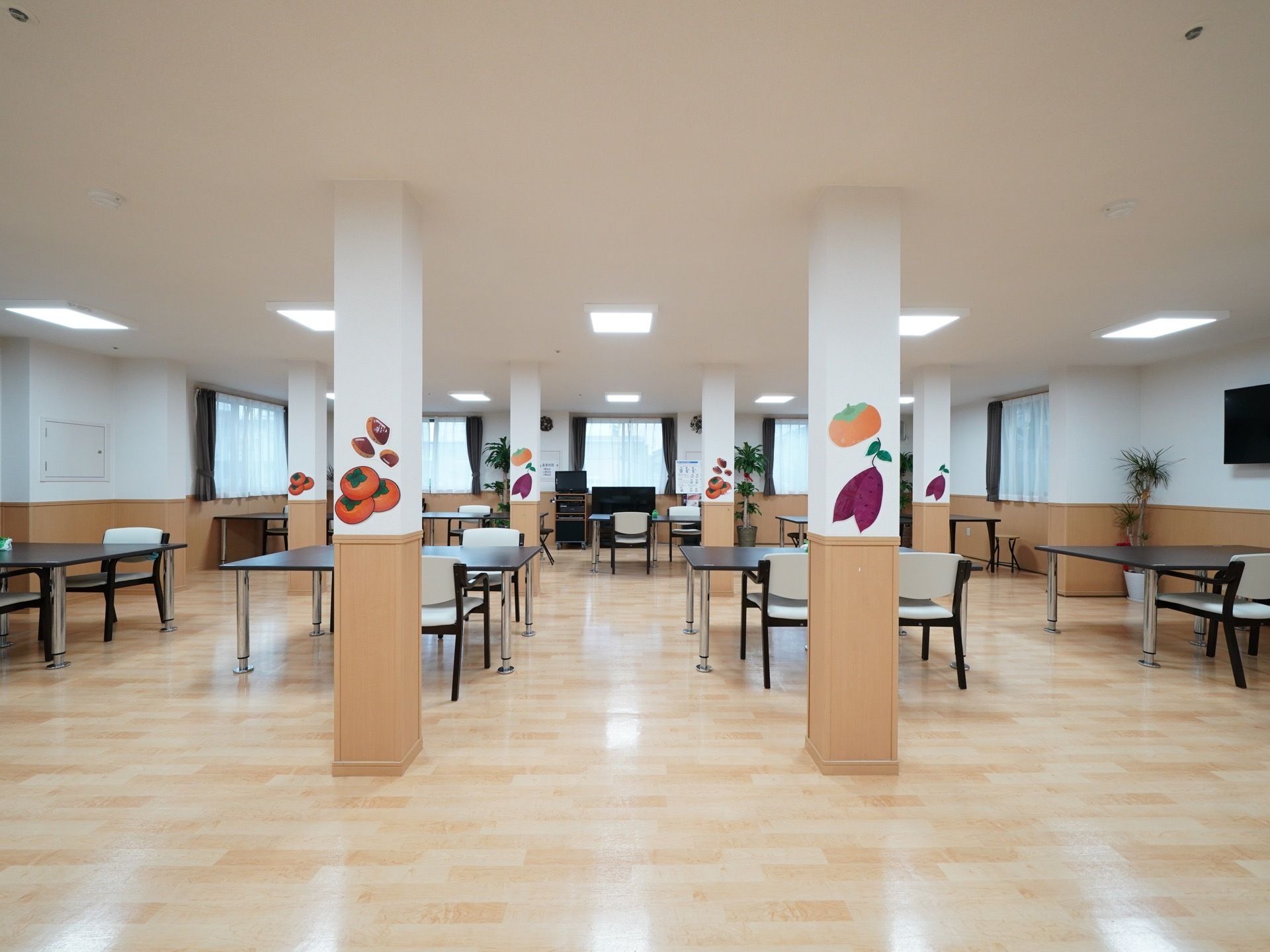 広々とした明るいスペースで、ゆったりくつろぐことのできる空間である。柱には季節の野菜や果物の絵が飾られている。