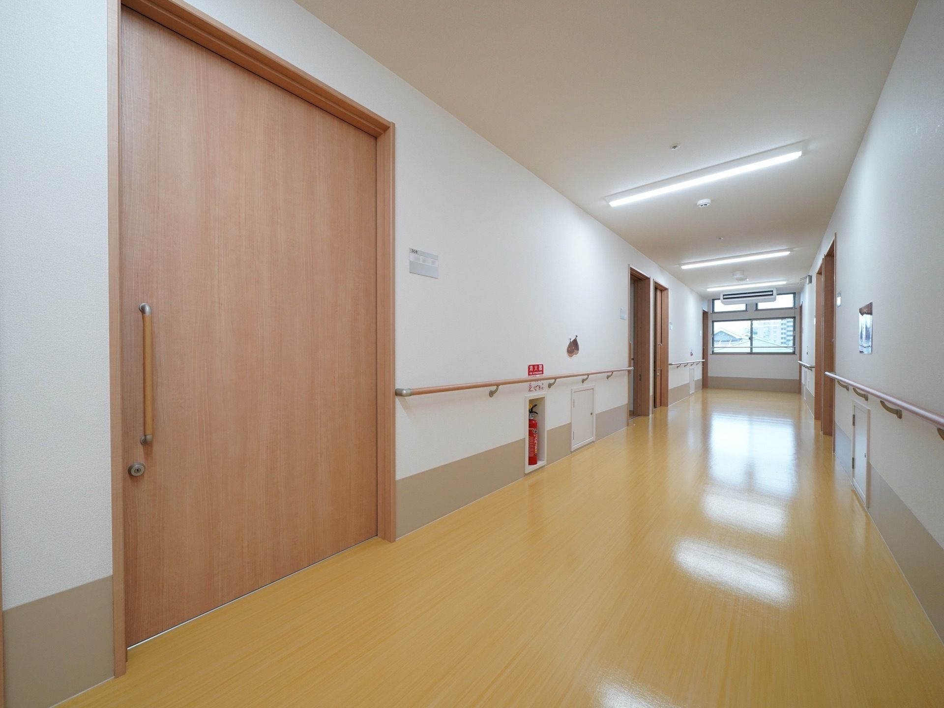 突き当たりに窓があり、明るく広い廊下である。大きな居室の扉はスライド式になっており、楽に開閉することができる。