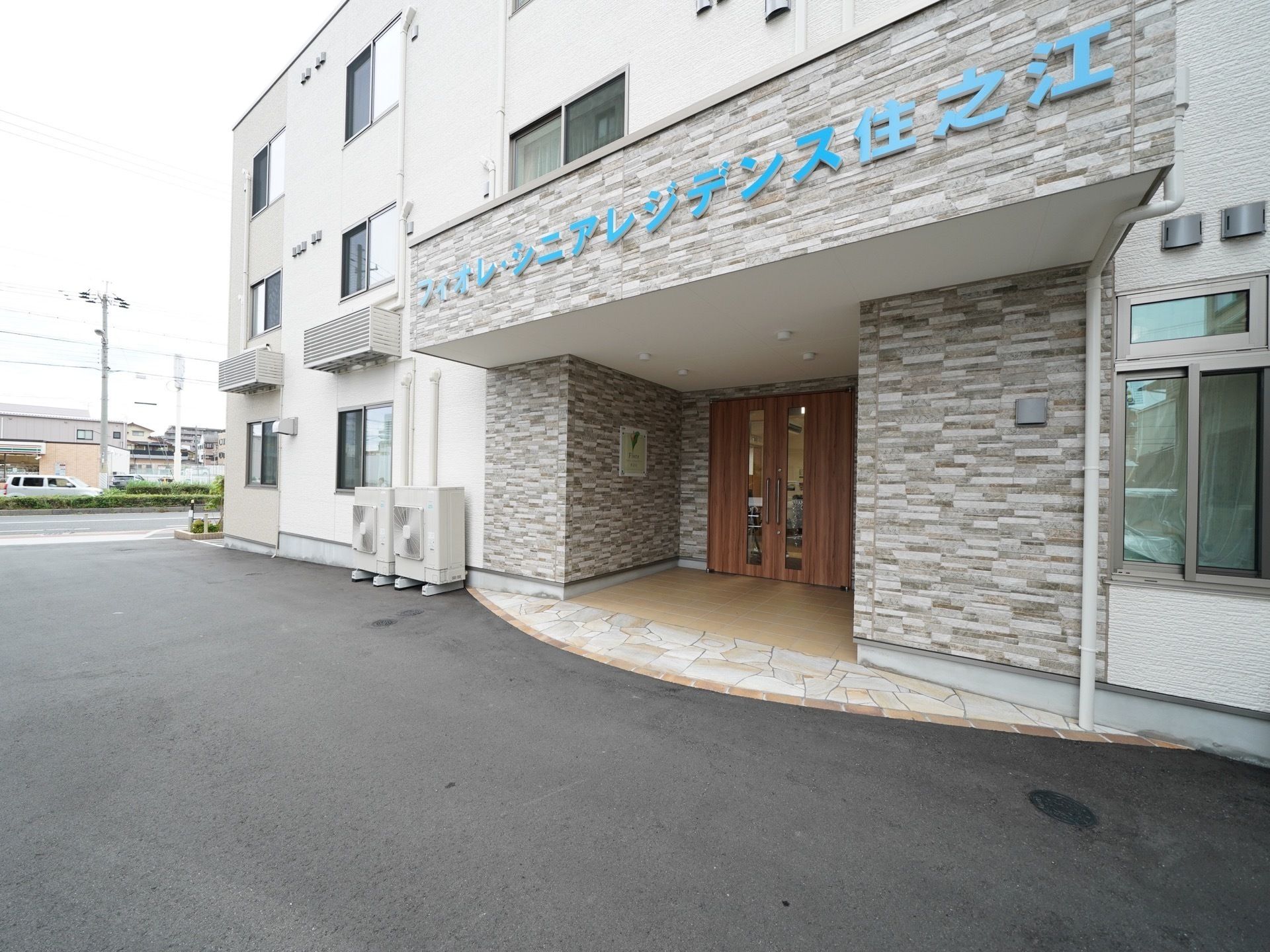 スリットから中がうかがえる重厚な木製の扉があるエントランス