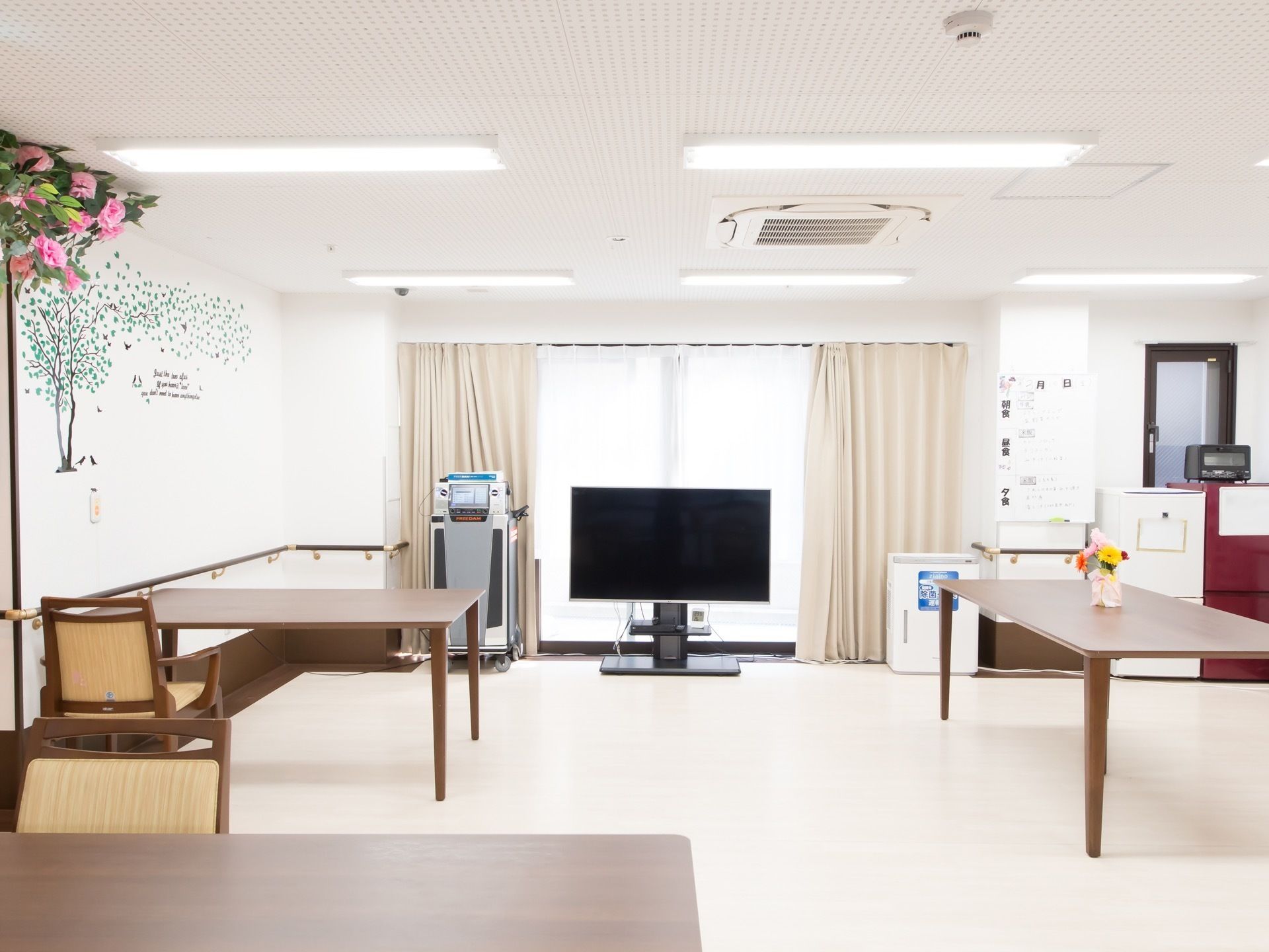 リビングは、白を基調とした明るくゆとりのある設計となっている。窓際には大画面のテレビとカラオケセットが置かれている。