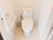 清潔感があり、さわやかな印象のトイレである。快適に利用できる温水洗浄便座器が完備され、横にL字型の手すりをつけている。