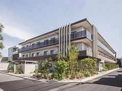 3階建てのこげ茶とオフホワイトの建物である。施設の周りには植物を植えているので、自然の中にいる雰囲気がある。