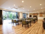 広々とした明るい清潔感のある空間で木目調の床が美しい。大きなテーブルとひじかけ付きのいすが完備でゆっくり食事ができる。