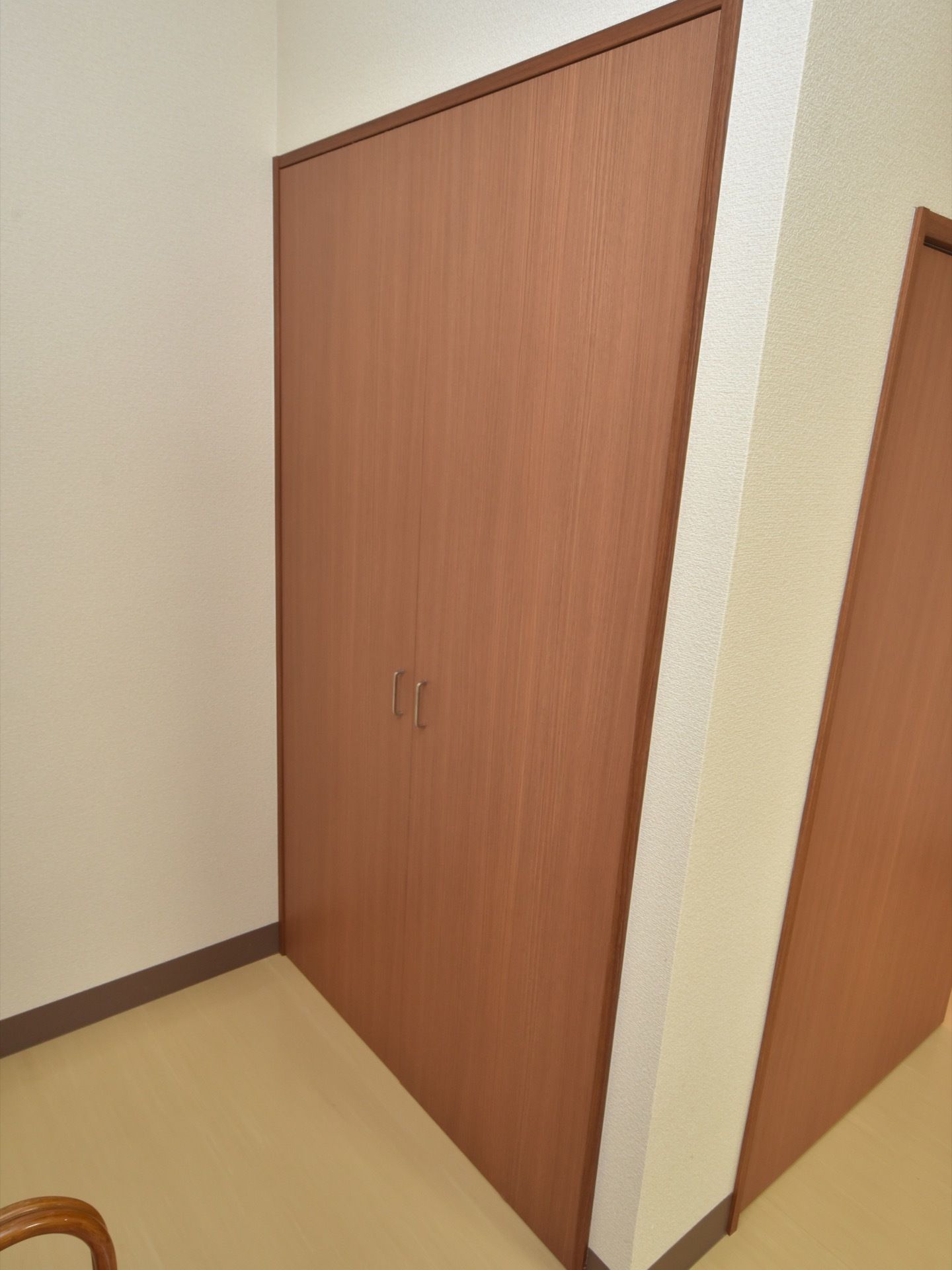 居室には広々としたクローゼットを備え付けている。扉は木目調のデザインとなっていて、観音開きの扉を採用している。