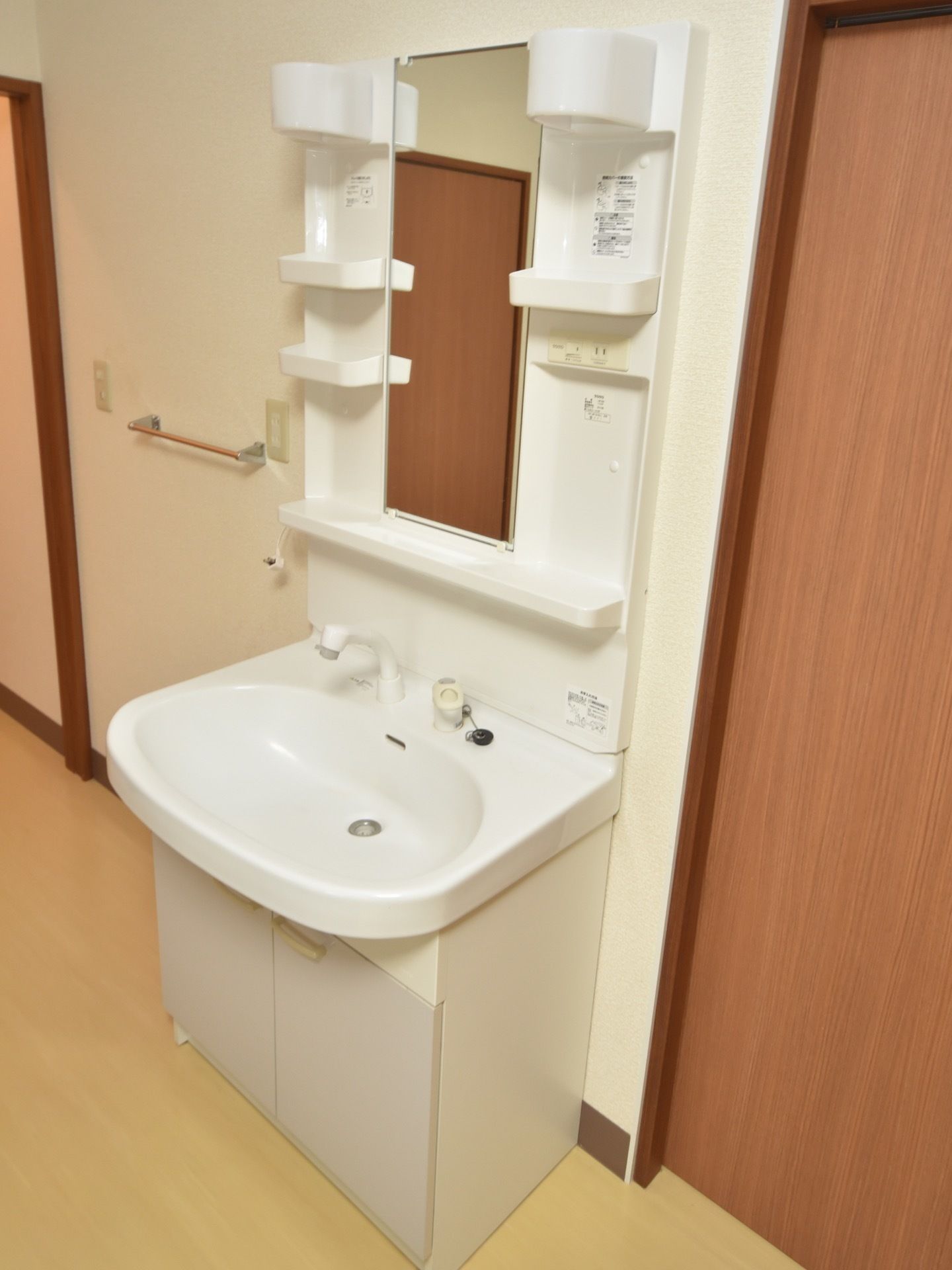 居室には収納スペースが多い、洗面化粧台を設置している。また洗面台の横にはタオル掛けがあり、コンセントを備え付けている。