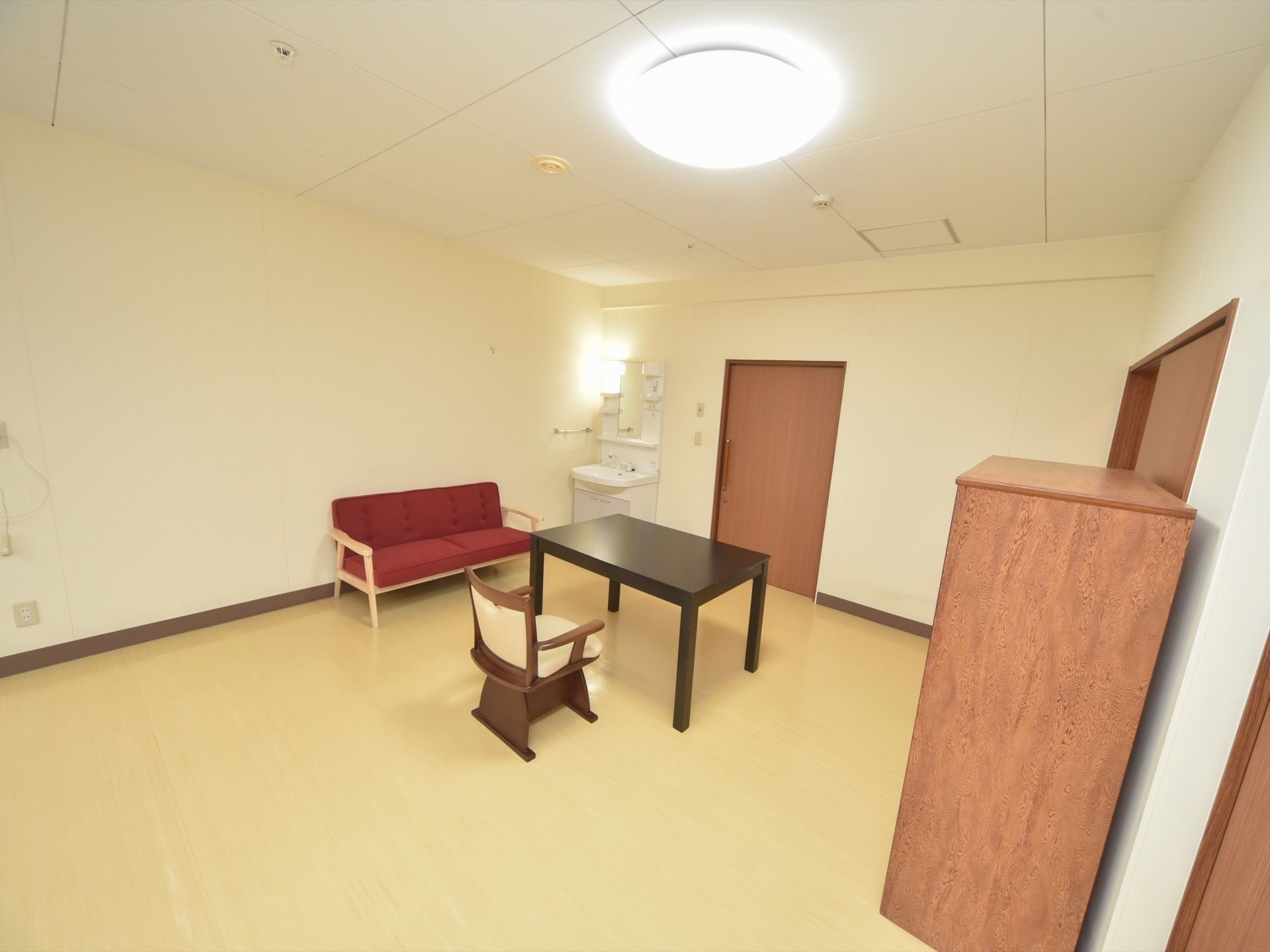 居室の天井には火災警報器があり、照明器具が取り付けられている。また部屋の入り口には、スライド式のドアを設置している。