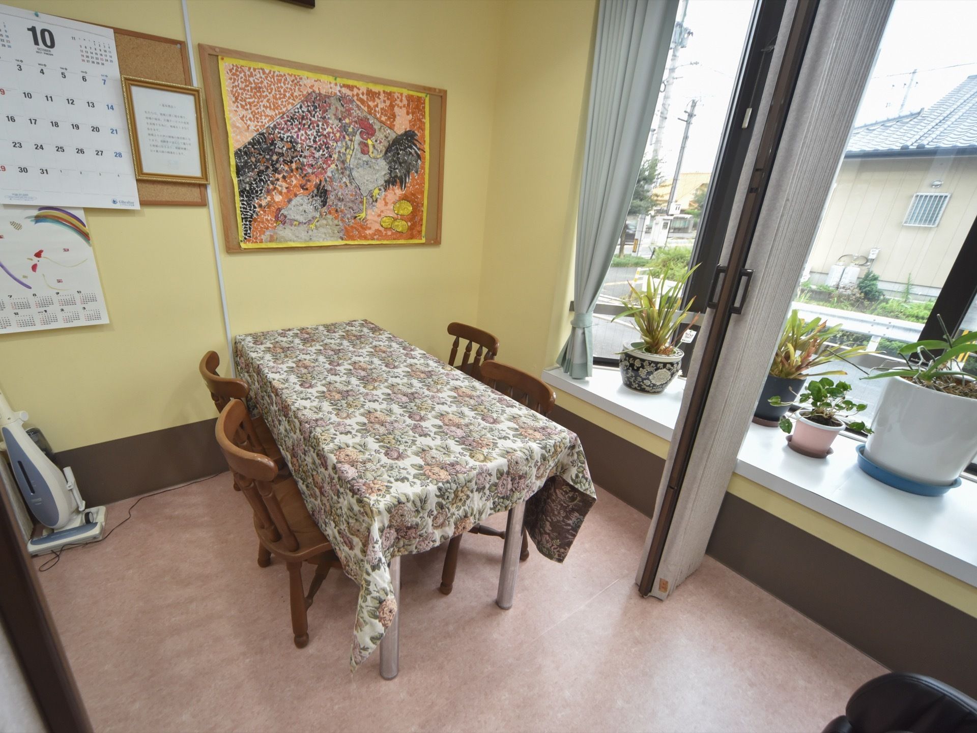 仕切りがついた談話室には、観葉植物が置かれた出窓を備え付けている。また壁にはメッセージボードがあり、カレンダーがかけられている。