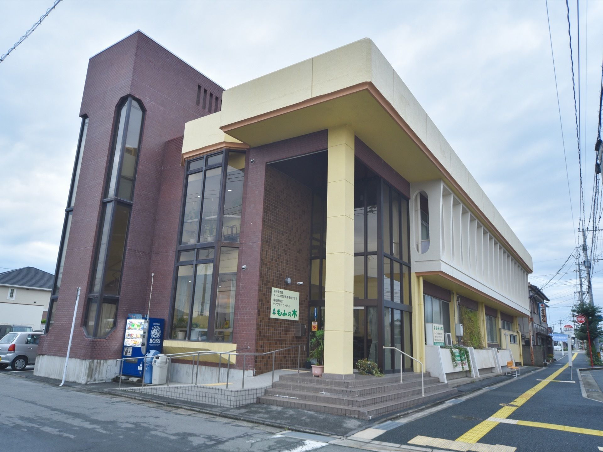 施設の外壁はベージュ色が基本で、エントランス付近にはブラウン色のタイルが貼られている。また玄関周りはガラス張りとなっている。