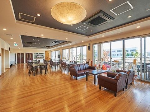柔らかい光の照明、木質系のフローリング、大きな広々とした窓があるダイニングルーム