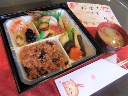 赤飯やたくさんの種類のおかずが入ったおせちのお重