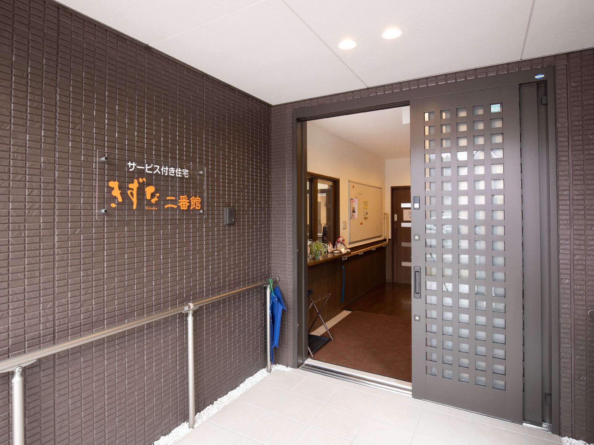 スライド式ドアの玄関までてすりが設けられているエントランスの様子