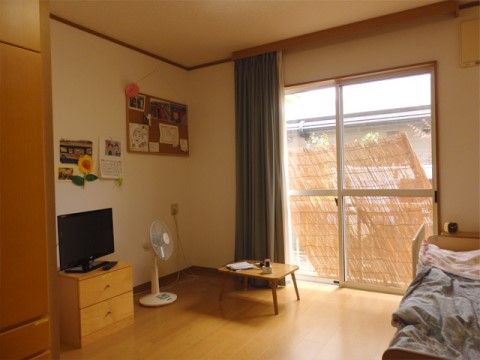 大きな掃き出し窓がある日当たりの良い居室。広いスペースが確保された室内は、入居者様のお好みの仕様で快適にお過ごしいただいている。