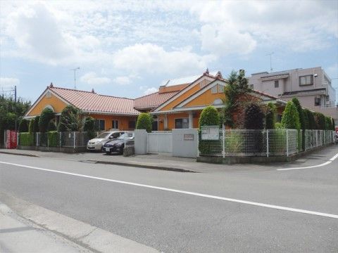 オレンジの壁がひときわ目をひく、平屋建ての施設外観