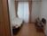 ベッド、椅子、家具などが置いてある部屋。床はフローリングになっている。カーテンの掛かった大きな窓がある。