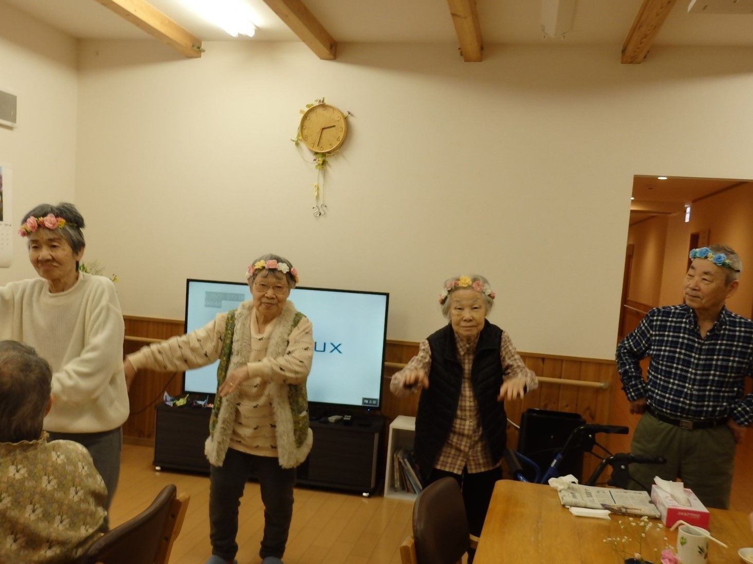 頭に飾りをつけて、音楽に合わせて笑顔で踊る入居者様