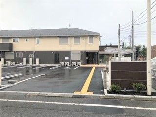 駐車場スペースががある施設内の敷地。奥の方にグループホームの建物がある