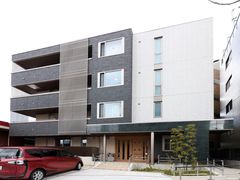 4階建ての建物はシックな色を基調としたシャープなデザインが特徴。敷地前に駐車場があり、スロープも完備しているので、移動もスムーズ。